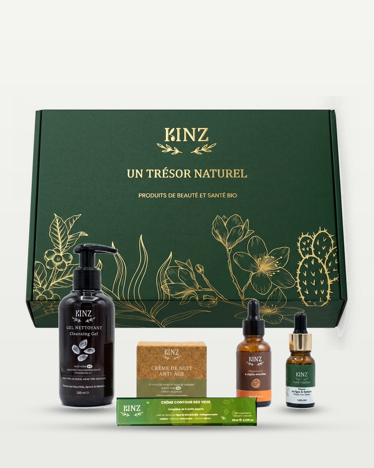 باقة Kinz لمكافحة الشيخوخة والإشراقة الطبيعية أمام علبتها الخضراء: جل التنظيف، كريم الليل المضاد للشيخوخة، سيروم فيتامين C، زيت بذور التين الشوكي وكريم محيط العين